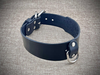 Black leather collar with metal hardware on a gray textured background