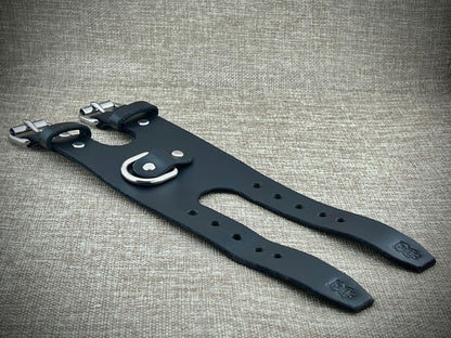 Black leather strap with silver buckle on a textured gray background