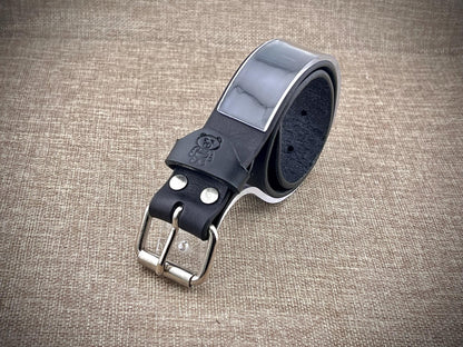 Black leather belt with silver buckle on a textured brown background