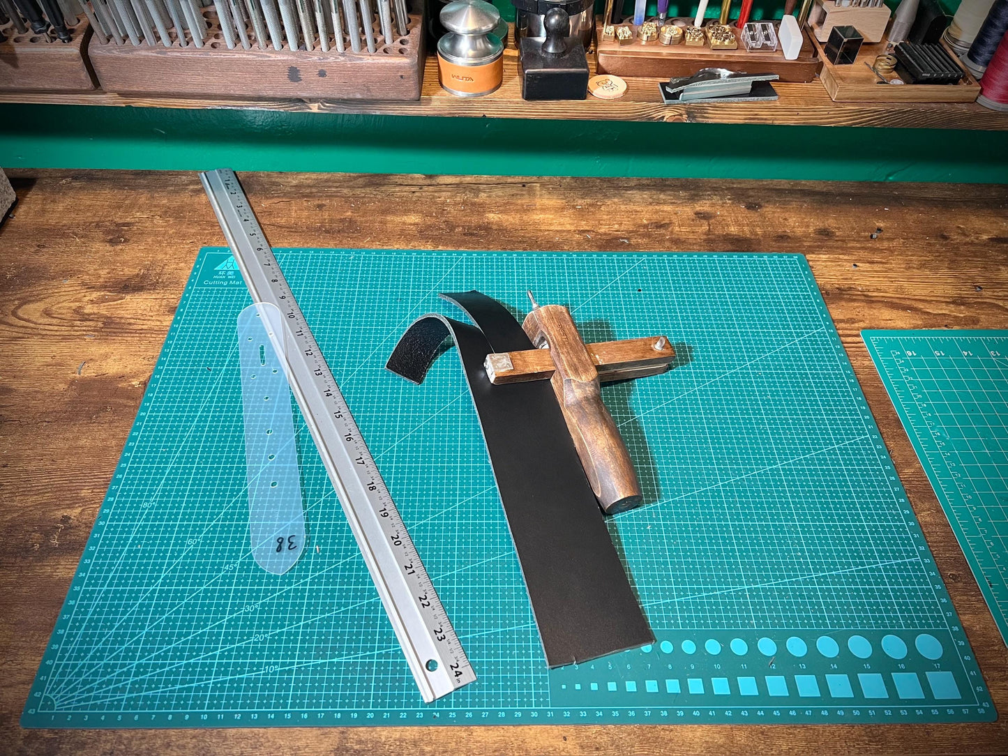 Crafting tools on a green cutting mat with a ruler
