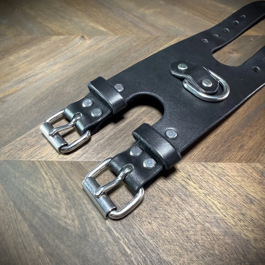 Detail macro view highlighting dual nickel-plated steel buckles riveted to a 3.5" black vegetable-tanned leather strap configuration.