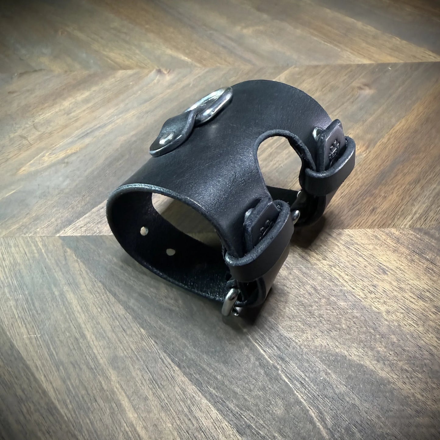 Rear profile view of a closed 3.5" black leather restraint cuff, showing dual adjustable straps secured via nickel-plated steel buckles.
