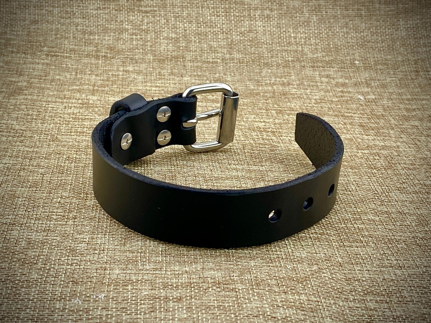 Profile perspective of a handcrafted 1" wrist cuff showcasing heavyweight 8oz American belt-weight leather, polished hardware surfaces, and sleek burnished edge construction.