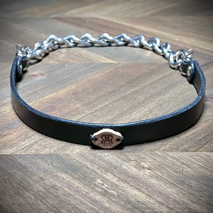 Front reveal of a 0.75" black leather subculture collar with heavy industrial nickel-plated steel chain and centered vegetable-tanned logo tag.