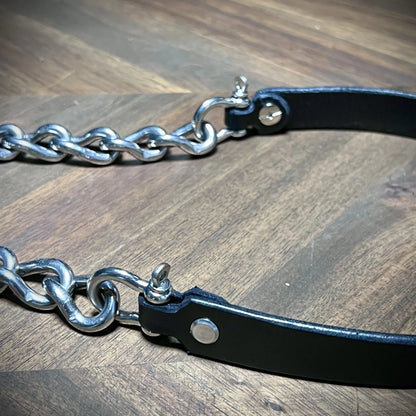 Close-up view of the terminal hardware attachments on a black leather chain collar, highlighting hand-finished edges and steel Chicago screws.