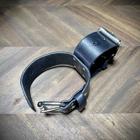 Product reveal angle of a pair of Knotty Oso X-connected cuffs bench-crafted from authentic 8oz vegetable-tanned leather, highlighting steel buckles.
