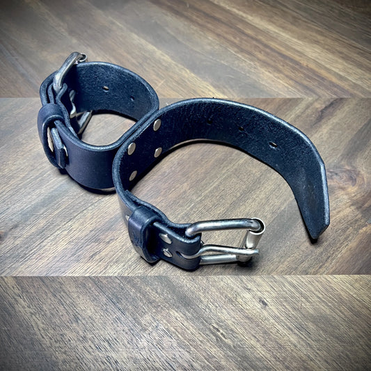 Profile view of connected 1.75" leather restraints with one side securely buckled and the other unfastened for positioning context.
