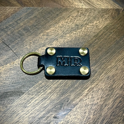 Personal initial embossed black leather keychain paired with solid brass hardware.