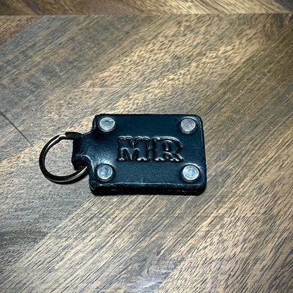 Custom initialed black leather keychain with stainless steel hardware and four corner rivets.