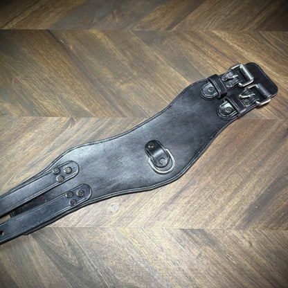 Flat lay view of an unbuckled black leather posture collar showing dual rear buckles and heavy-duty Chicago screws built for consensual anchoring.