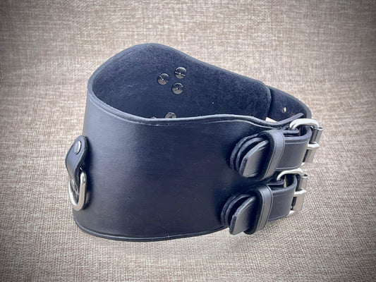 Black leather collar with metal clasps on a textured gray background