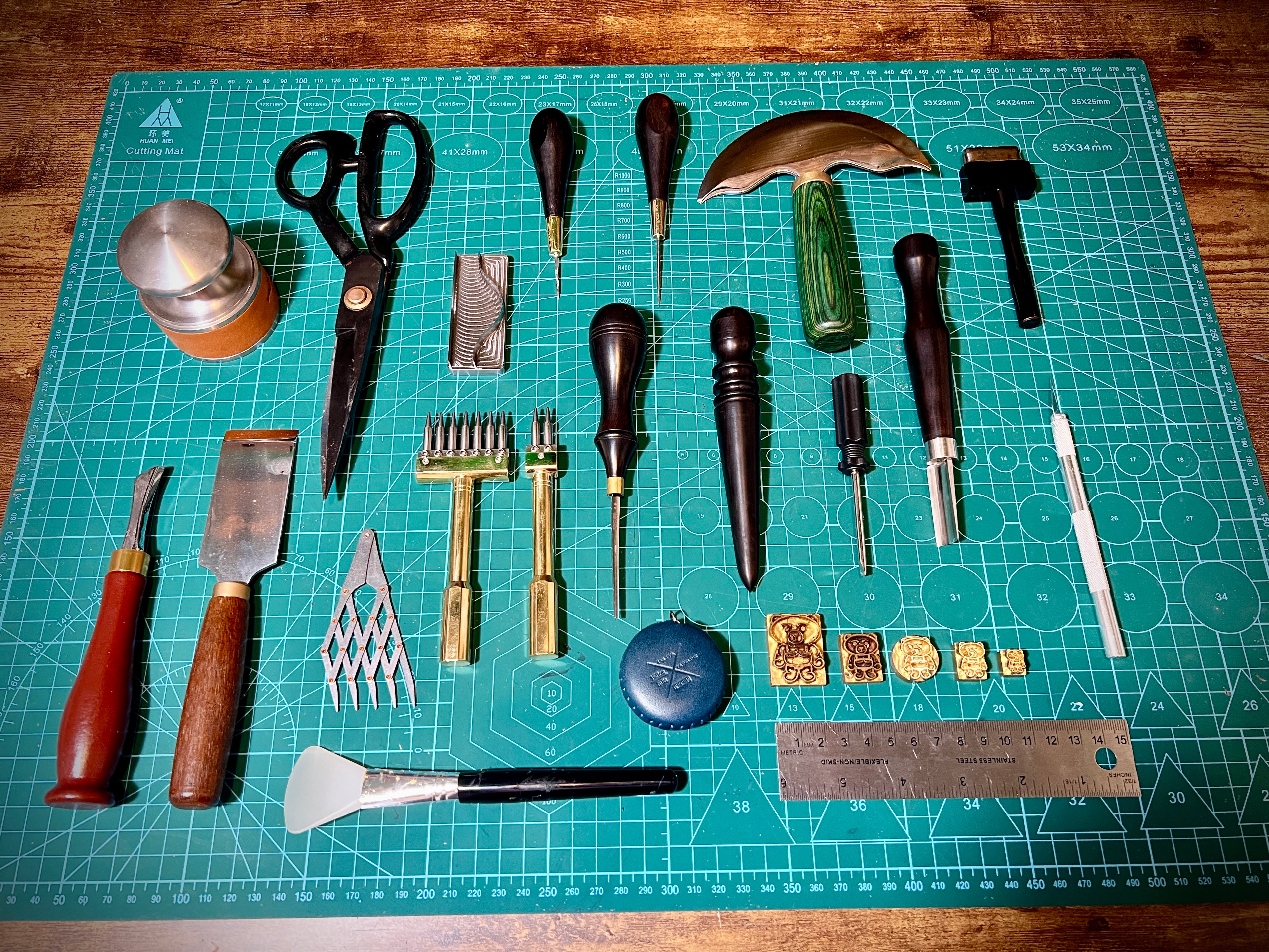 Set of leatherworking tools on a green cutting mat