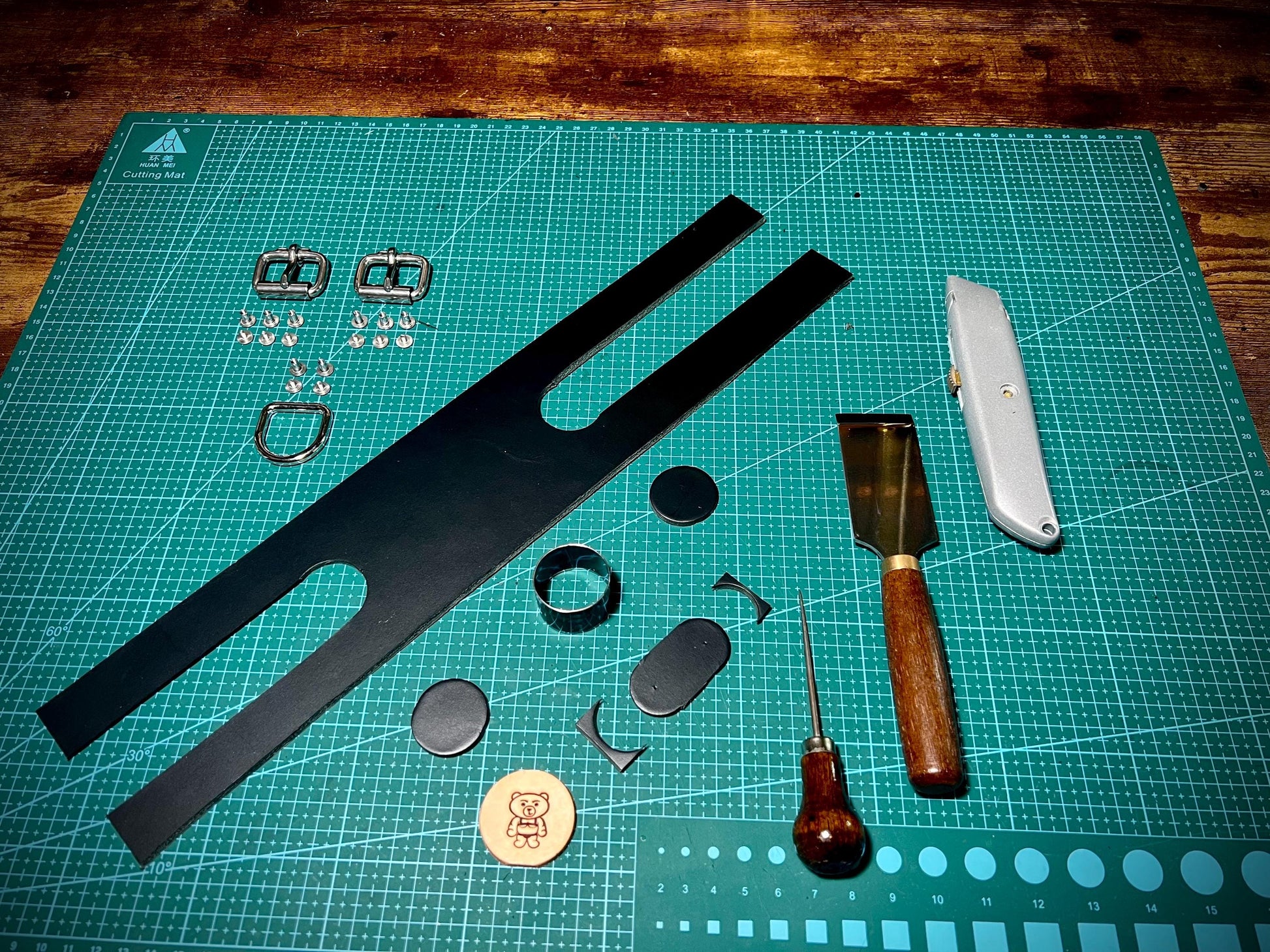 Set of leatherworking tools and materials on a cutting mat