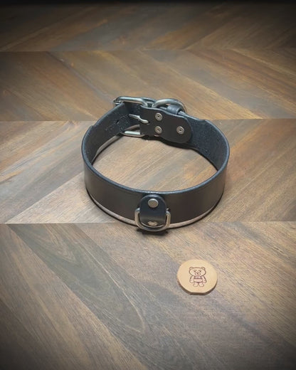 Demonstrating the functional flexibility and hardware locking action of a 1.75" black leather collar with nickel-plated steel hardware.