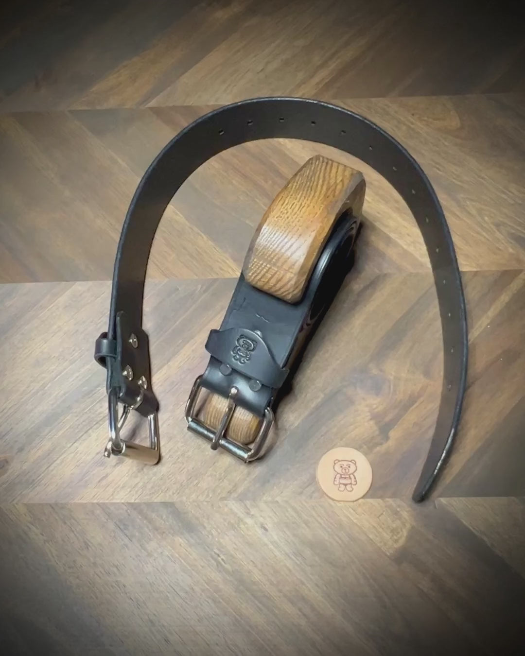 Manual demonstration buckling a heavy 1.75 inch black leather restraints through a steel roller closure.