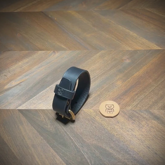 Demonstrating the unbuckling of a 1" black leather cuff to reveal the interior grain and solid brass hardware parameters.