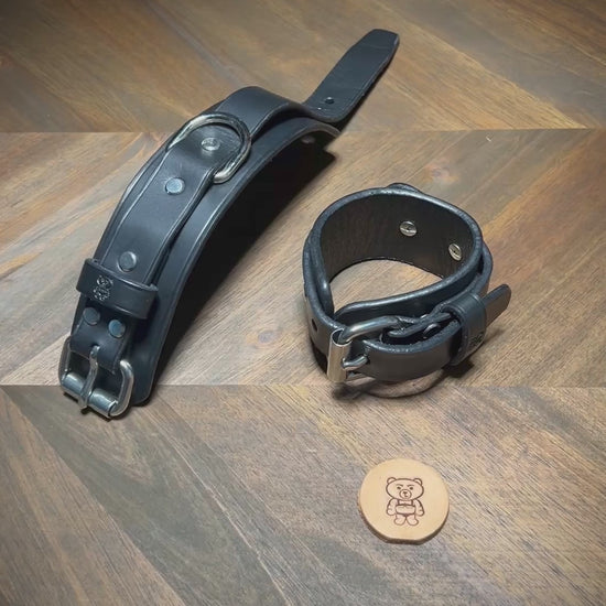 Manually unbuckling a 1.75" wide black leather two-piece cuff to demonstrate hardware operation and dual-layer structural flexibility.