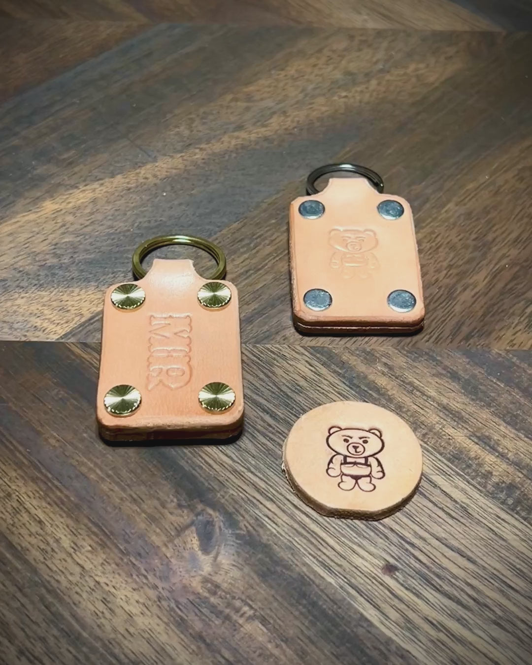Manual demonstration unfastening screw posts on a personalized natural leather keychain to open the layered body structure.