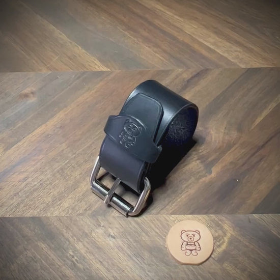 Unbuckling and demonstrating the flexibility of a 1.5" black leather wrist cuff with nickel-plated steel hardware.