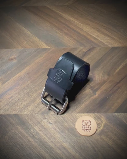 Unbuckling and demonstrating the flexibility of a 1.5" black leather wrist cuff with nickel-plated steel hardware.