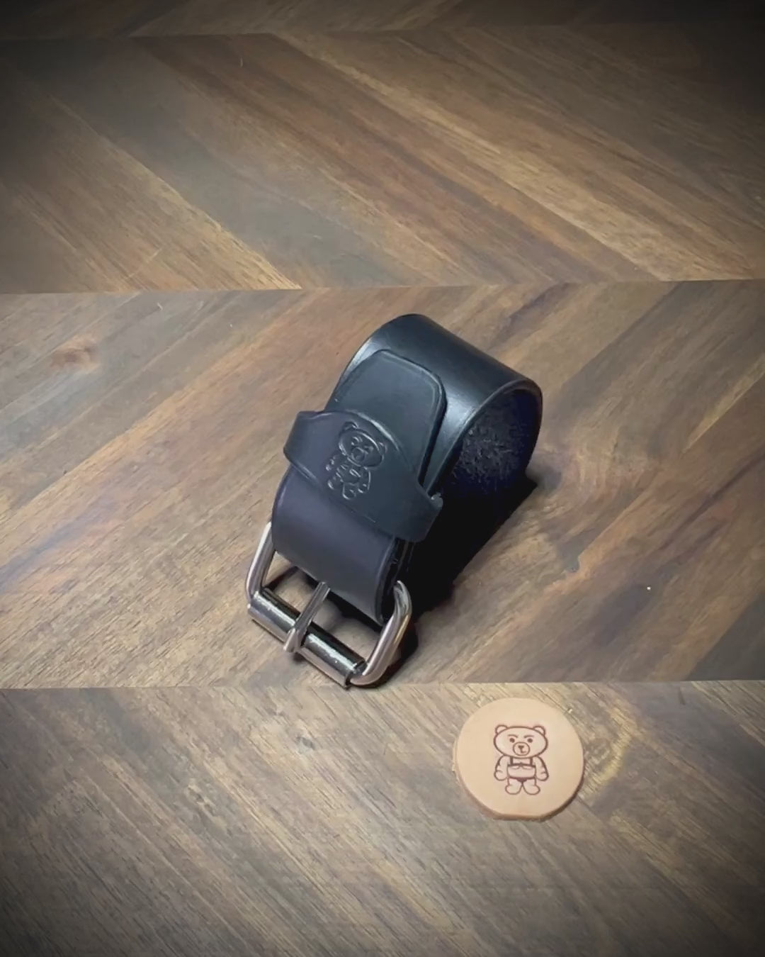 Unbuckling and demonstrating the flexibility of a 1.5" black leather wrist cuff with nickel-plated steel hardware.