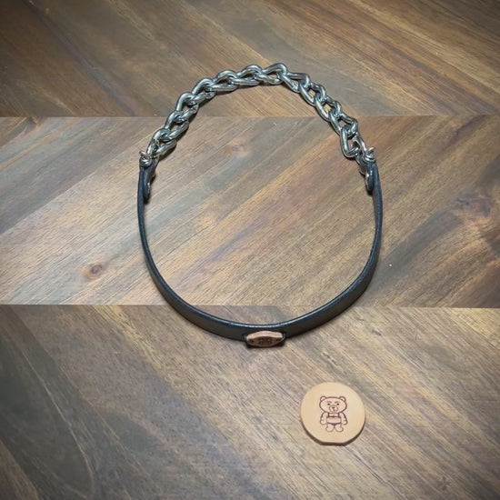 Demonstrating the heavy-duty flexibility and articulating nickel-plated chain components of a handcrafted black leather collar.