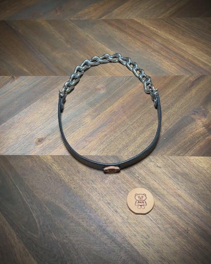 Demonstrating the heavy-duty flexibility and articulating nickel-plated chain components of a handcrafted black leather collar.