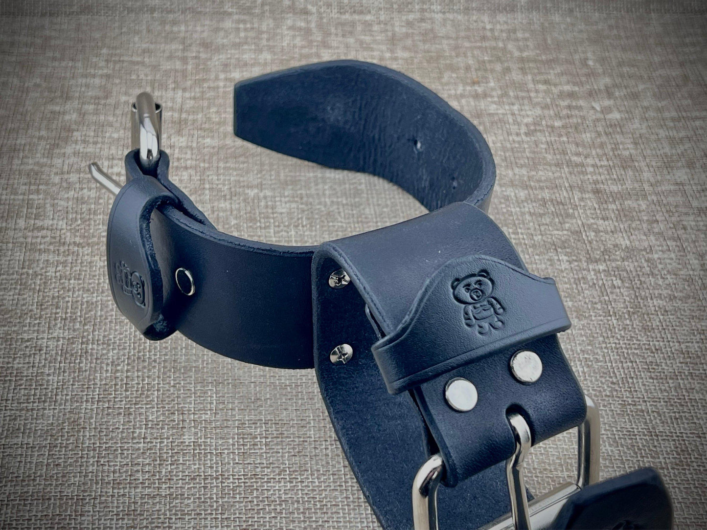 Pair of wrist cuffs with metal hardware on a textured gray background